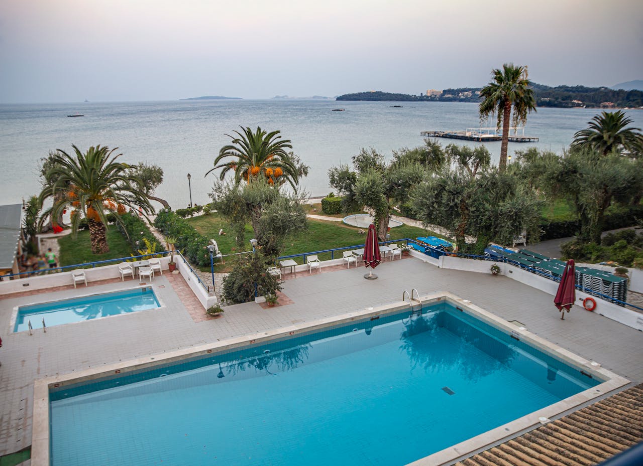 Beautiful view of a swimming pool overlooking the Ionian Sea in Corfu, Greece, during a serene summer day.